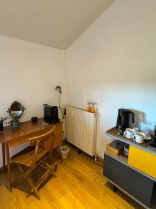 a kitchen with a table and a desk with a table at Chambre au calme & salle de bain privée in Divonne-les-Bains