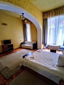 a bedroom with a large bed in a room with windows at Aki Apartment in Braşov