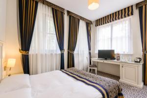 a bedroom with a bed and a desk and windows at Park Rekreacyjno-Biznesowy Las Woda in Wilga