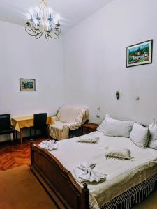 a bedroom with two beds and a chandelier at Aki Apartment in Braşov