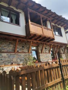 a house with a wooden fence in front of it at Къщата на музиканта in Leshten