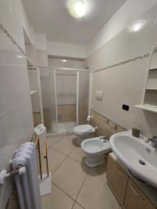 a white bathroom with a toilet and a sink at la Maison del Prof in Barletta