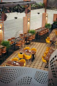 un restaurante vacío con mesas y sillas amarillas en Atmosfera Bengaluru, India, en Bangalore