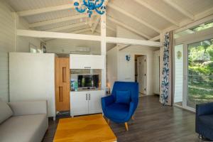 a living room with a blue chair and a couch at Sakli Gol Evleri in Karacaören