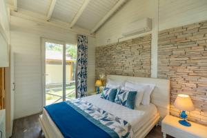 a bedroom with a bed and a brick wall at Sakli Gol Evleri in Karacaören