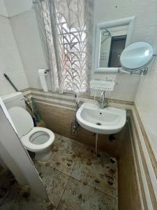 a bathroom with a toilet and a sink and a mirror at Aura House Homestay in Guwahati