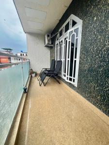 a balcony with chairs on the side of a building at Aura House Homestay in Guwahati
