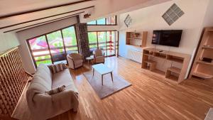 a living room with a couch and a tv at Venus - Apartamente de închiriat in Buşteni