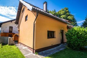 a small yellow house with a yard at Casa Kavran in ŽeljezničkaStanica )) (( Skrad