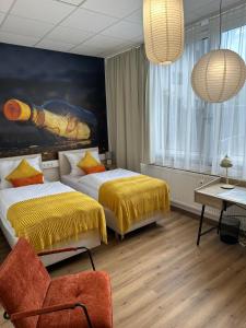 a hotel room with two beds and a chair at Renatus Apartments in Eschau
