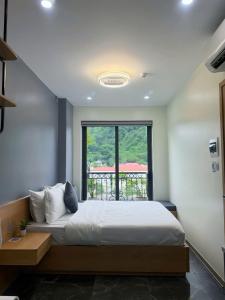 a bedroom with a bed and a large window at Sky Hotel & Homestay Ha Giang in Ha Giang