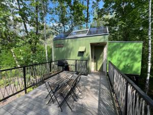 a green house with a bench on a deck at Posed U HRADU in Jaklovec