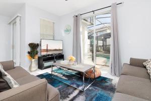 Una sala de estar con un sofá y un televisor. en Bright townhouse near Disney w pool & grill, en Kissimmee