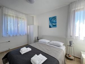a bedroom with a bed with two towels on it at Flowers Apartments Pula, city center 2 in Pula