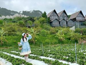 a woman in a dress standing in a garden at Đà Lạt Thiên Vương Homestay in Lạc Dương