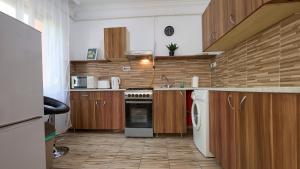 Una cocina con gabinetes de madera y un horno de estufa. en Tarsoly kertes nyaraló, en Hajdúszoboszló