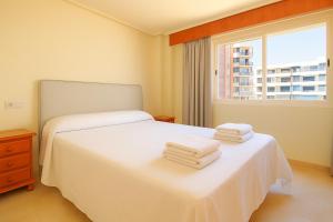 a bedroom with two beds with white sheets and a window at Riurau Home - Primera línea in Calpe