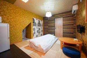 a bedroom with a bed and a table and a yellow wall at 伏見稲荷 -菊- in Kyoto
