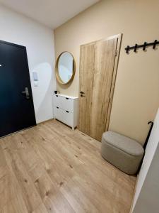 a room with a door and a chair and a mirror at Anna Apartment in Dunajská Streda