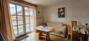 a living room with a table and a couch at BIO-Bauernhof Rhön in Schleid