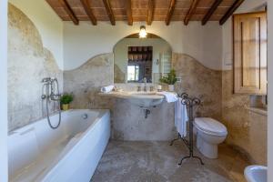 un bagno con vasca, lavandino e WC di CASALE DEI 12, Emma Villas a Montepulciano Altre 40 foto