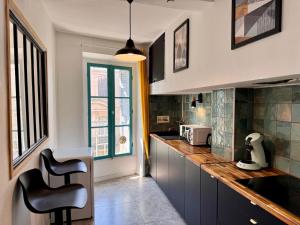 una cocina con encimera y algunas sillas. en Appartement Minervoise - Gare Carcassonne, en Carcassonne