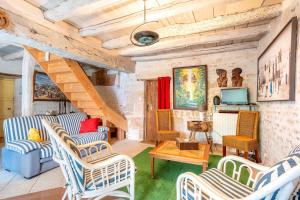 a living room with chairs and a staircase at Chez Jacques in Saint-Martin-de-Fraigneau