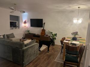 a living room with a couch and a table with a guitar at Room at Wallington Green for professionals, free parking, near station, 30 min to London Bridge, 27 min to LDN Victoria in Wallington