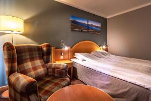 a hotel room with a bed and a chair at Bergo Rom in Beitostøl
