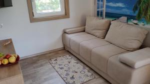 a living room with a couch and a bowl of fruit at Sunrise Wellbeing mobile home for mindful, vegetarian, active rest, just 35 meters from the sea in Grebaštica