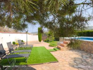 a yard with chairs and a swimming pool at Casa Rural Prado Alto,Foz Calanda in Foz-Calanda