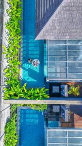 a person swimming in a swimming pool with plants at Javana Royal Villas in Seminyak