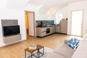 a living room with a couch and a kitchen at Casa Vacanza Cry in Adro