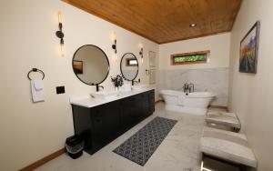 une salle de bain avec un lavabo, une baignoire et un miroir dans l'établissement Edgewood Retreat, à Gatlinburg 42 autres photos