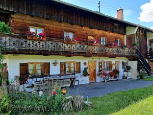 a wooden house with a table in front of it at Ferienwohnung in Niederhasling in Irschenberg
