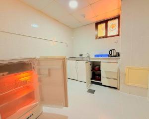 a kitchen with an empty refrigerator and a counter at Al Buhaira Hotel Apartment in Sharjah