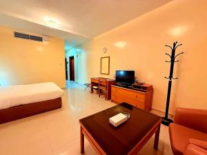 a hotel room with a bed and a tv at Al Buhaira Hotel Apartment in Sharjah +50 photos