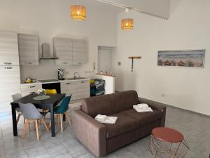 a living room with a couch and a table and a kitchen at La Casa di Baia in Bacoli