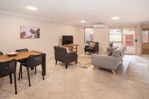 ein Wohnzimmer mit Tisch und Stühlen in der Unterkunft HME Collection Margaret River Townhouse 1 in Margaret River Town