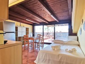 バーリにあるLo Scoglio Apartmentのベッド1台付きの部屋、テーブル付きのキッチンが備わる客室です。 +33枚の写真