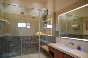 a bathroom with a glass shower and a sink at Rekys Home in Udaipur +31 photos
