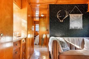 a living room with a couch and a black wall at Vintage Spartan-retro Farm Stay W Ev Charger in Arroyo Grande