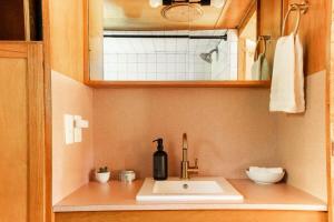 a bathroom sink with a bottle of wine on it at Vintage Spartan-retro Farm Stay W Ev Charger in Arroyo Grande +26 photos