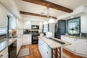 ReisterstownにあるClean & Spacious Modern Farmhouseのキッチン(白いキャビネット、黒の電化製品付)
