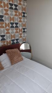 a bedroom with a white bed and a wall at Le domaine du Champ Han in Saint-Hilaire-du-Harcouët
