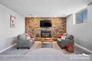 a living room with two couches and a stone wall at Family Retreat W Game Room & Fire Pit in Arvada