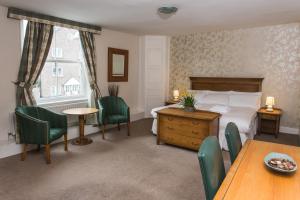 pokój hotelowy z łóżkiem, stołem i krzesłami w obiekcie Waggon and Horses w mieście York
