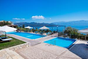 a resort pool with a view of the water at Ionion Fos in Nikiana