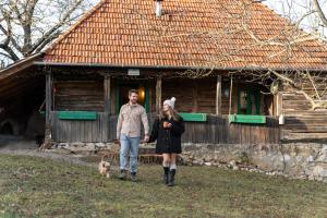 a man and a woman standing in front of a house at Casa Batrana in Zece Hotare