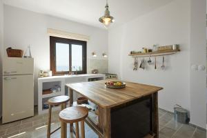 a kitchen with a wooden table and two stools at The Light House Chorefto in Chorefto